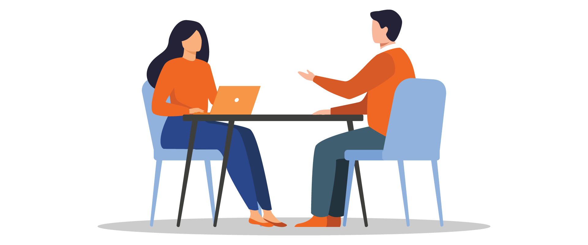 Two people sitting at a desk talking.